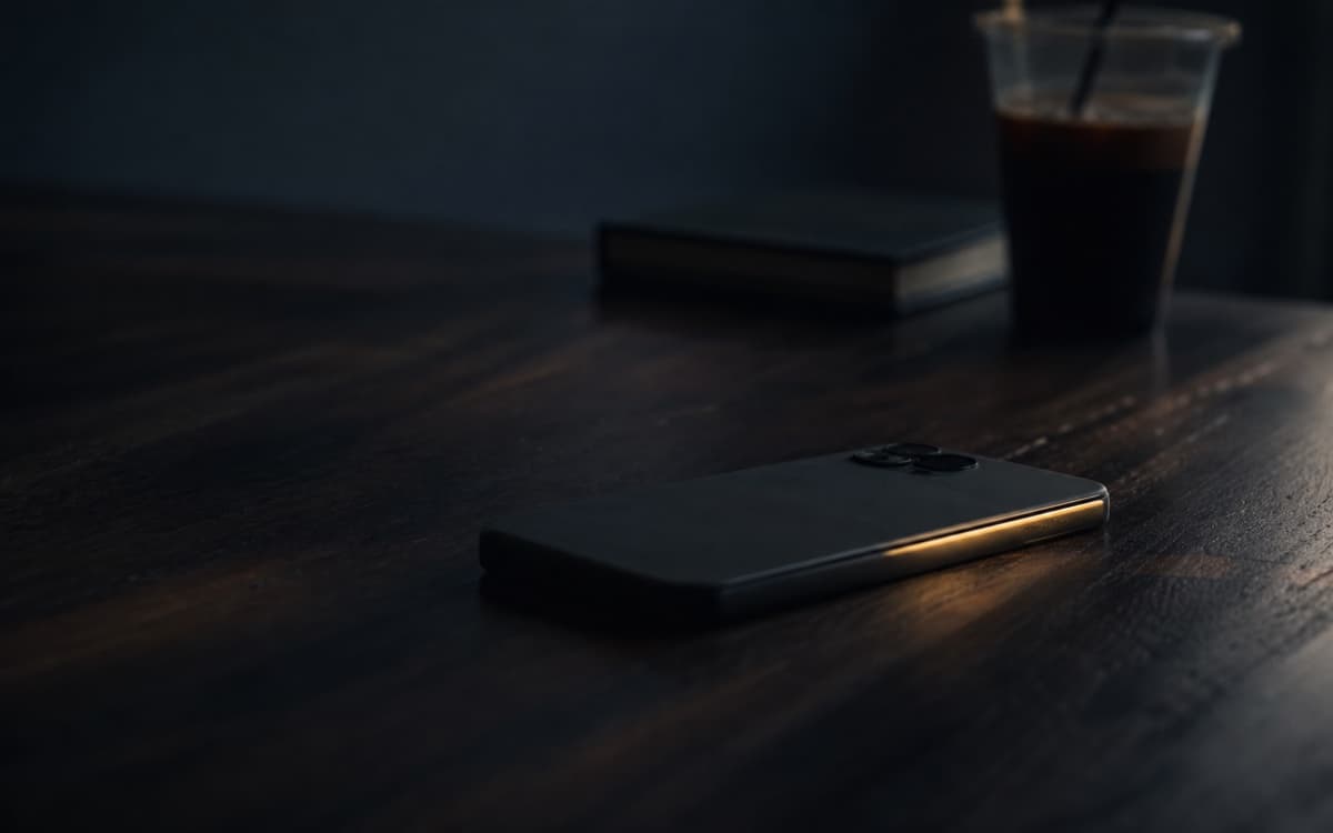 暗い机に伏せて置かれたスマートフォン